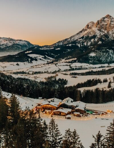 Die Almhütte mitten in den Bergen im Winter umringt von Gipfeln