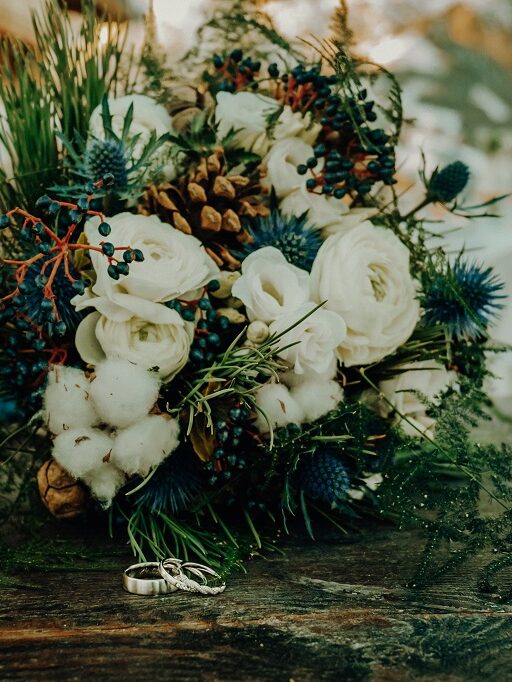 Wedding rings and bridal bouquet beautifully photographed by the wedding photographers in winter