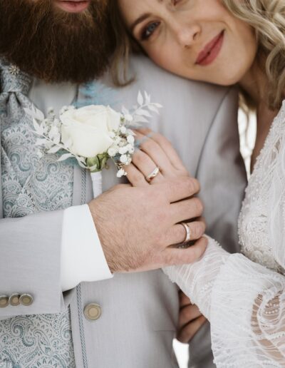 Detailaufnahme von Eheringen und Boutonniere auf einer Berghochzeit im Winter in einer Luxuslocation im Allgäu