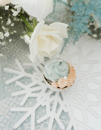 Cupcake als Tischdekoration und Gastgeschenk auf einem Platzteller aus Acrylglas auf einer Berghochzeit im Winter