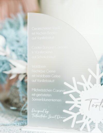 Tortenschild auf einer Winterhochzeit in den Bergen mit leckeren Geschmacksrichtungen