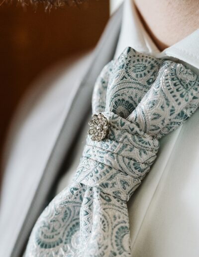 Detailaufnahme der Krawatte des Bräutigams an seinem Hochzeitstag im Winter in den Bergen