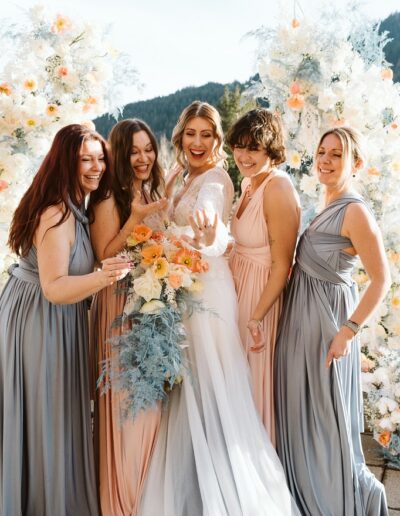Brautjungfern und Braut vor dem Traubogen für ein Gruppenfoto auf einer Winterhochzeit