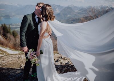 Brautpaar beim Fotoshooting auf dem Zwölferhorn im Salzkammergut in den Bergen