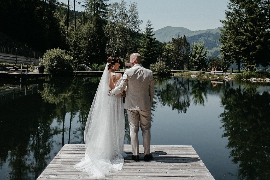 Brautpaar an einem Steg am See mit Bergpanorama auf ihrer Hochzeit am Berg in Österreich