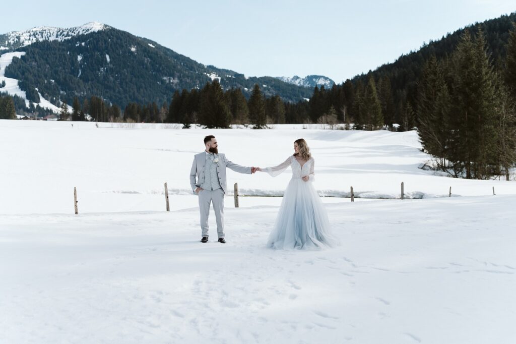 Brautpaar bei ihrer Winterhochzeit im Schnee nach der Verlobung