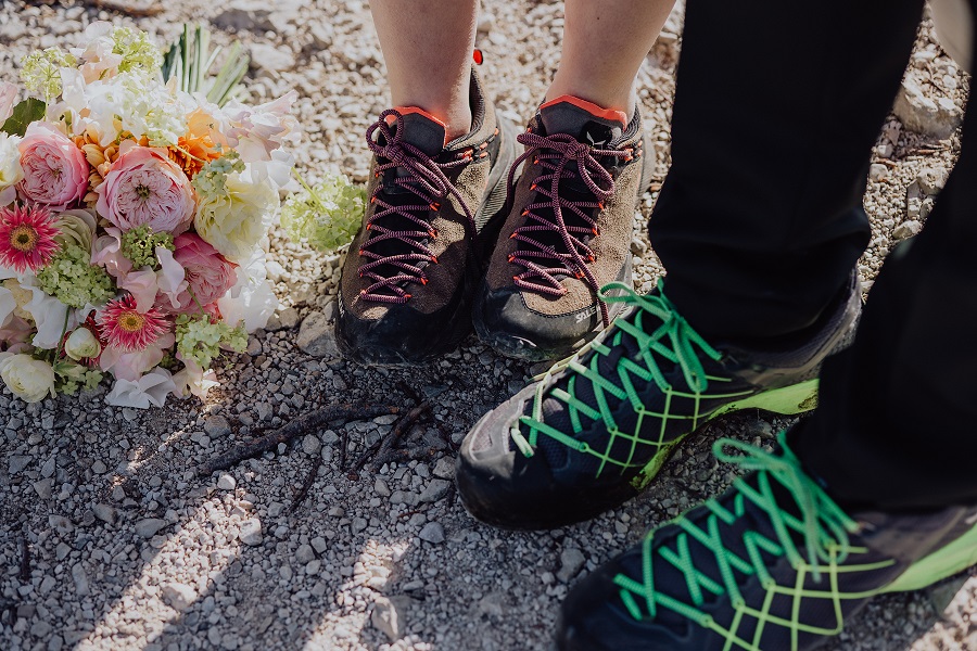 Heiratsantrag in den Alpen mit Wanderschuhen am Gipfel