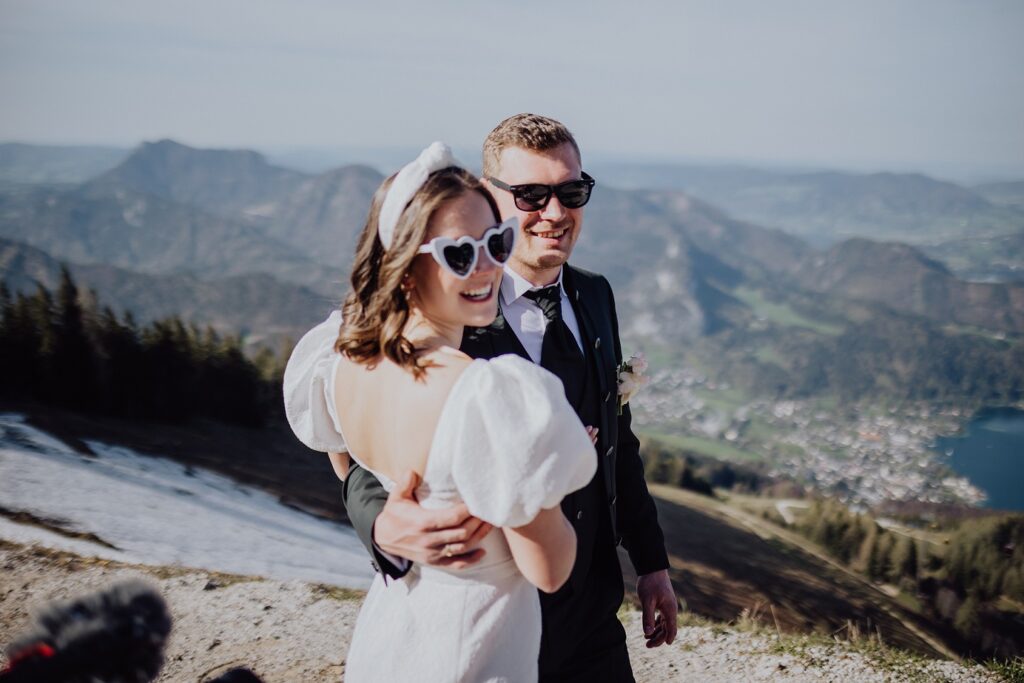 Brautpaar mit Sonnenbrillen im Frühling in den Bergen