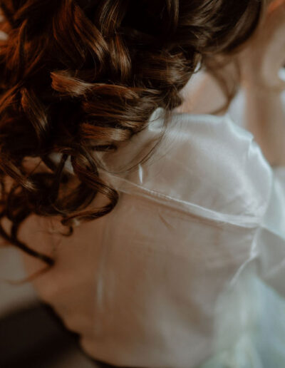 Braut beim Getting Ready in Tirol vor winterlicher Bergkulisse