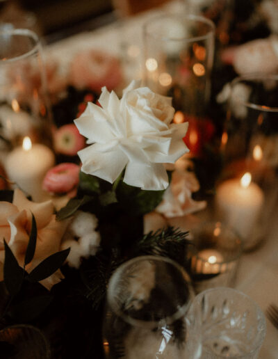 Tischdekoration mit Kerzen und Blumen bei Winterhochzeit in Tirol