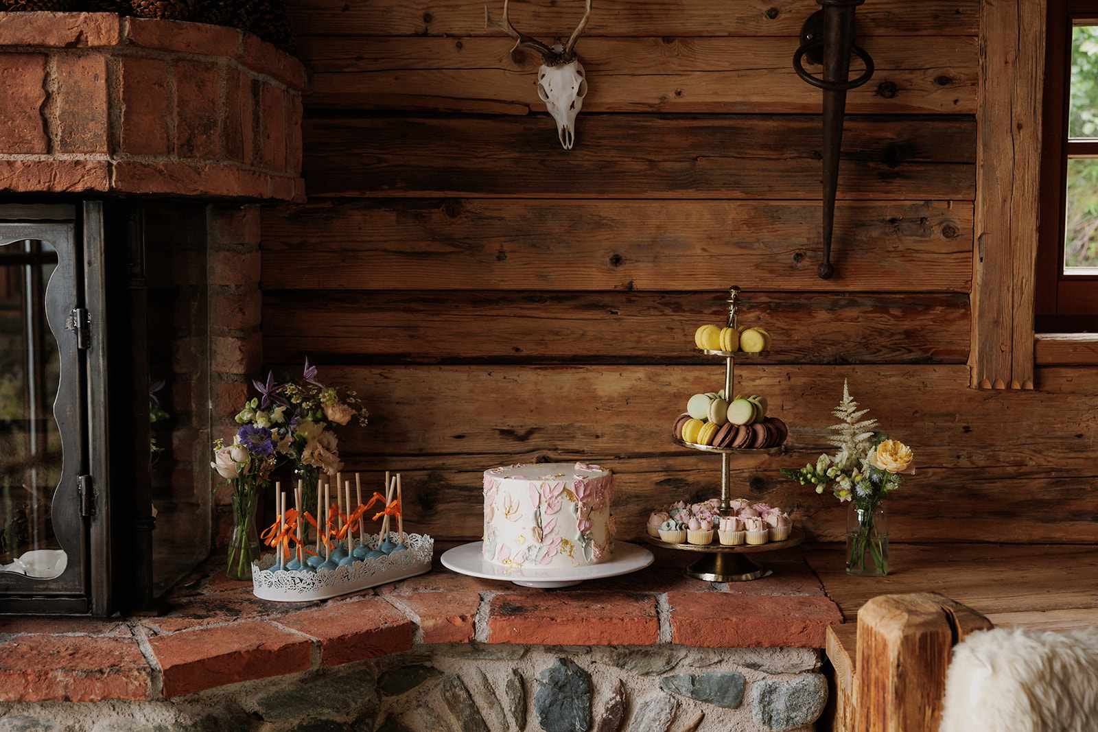 Sweet table with wedding cake, cake pops & macarons at a wedding in the mountains