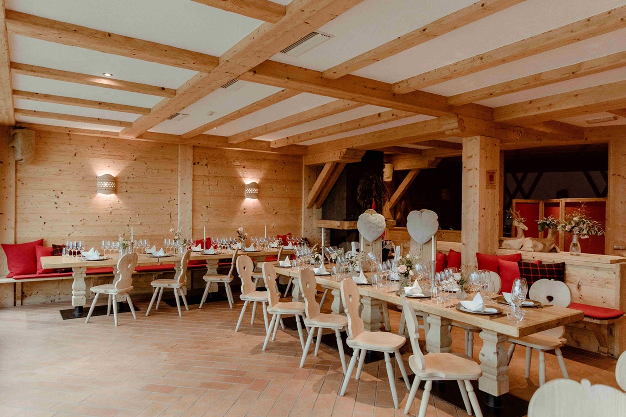 Gemütliche Almhütte mit hellen Holzwänden und liebevoll gedeckten Tischen für eine stilvolle Berghochzeit in Südtirol – perfekt für eine Hochzeit in den Alpen mit modern-alpinem Flair.